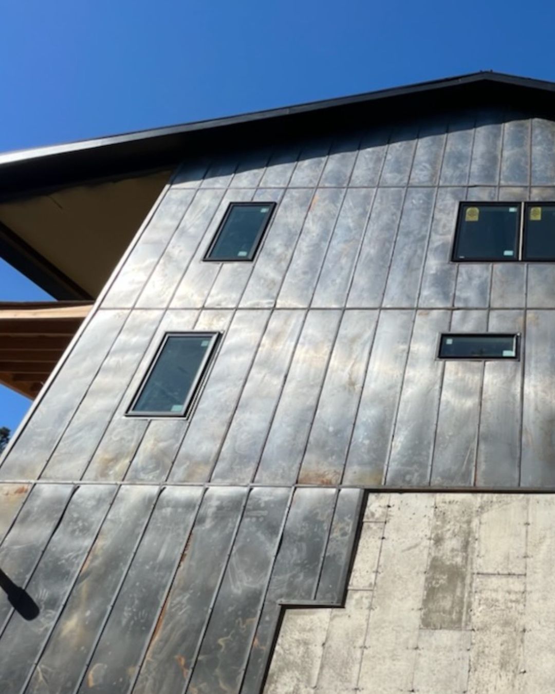 Raw zinc finish vertical metal panel siding on a Colorado home